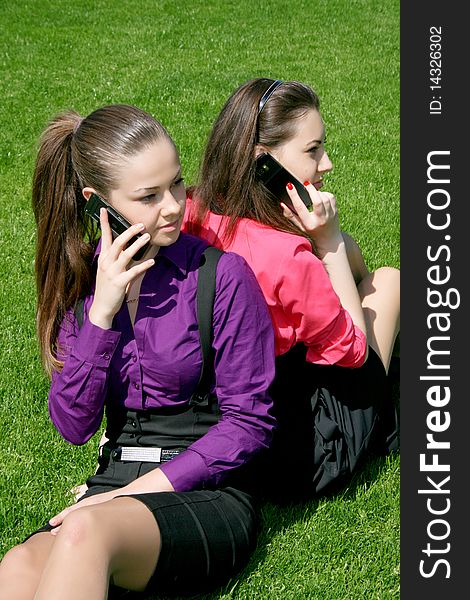 Two young businesswomen calling by phone