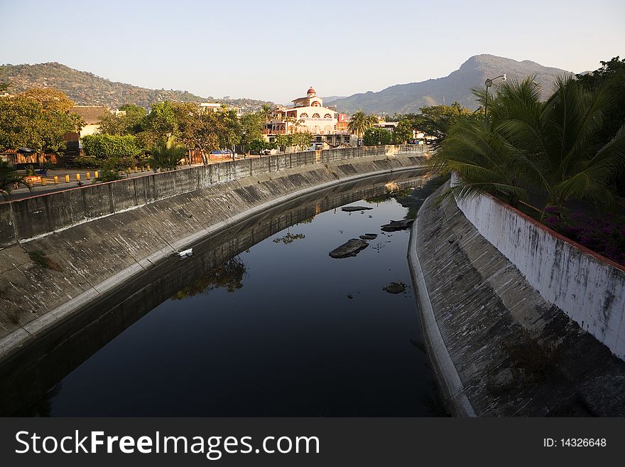 A brightly colored hospital along a quiet canal in the morning on the Pacific Coast in Mexico. A brightly colored hospital along a quiet canal in the morning on the Pacific Coast in Mexico.