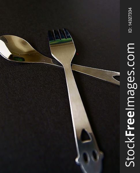 Spoon and fork isolated on black background