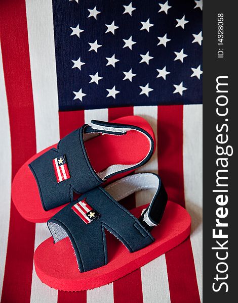 Pair of children's patriotic sandals on an american flag background - very red,white, and blue!. Pair of children's patriotic sandals on an american flag background - very red,white, and blue!