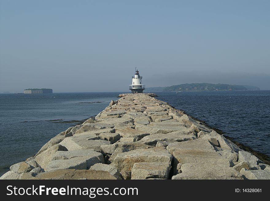 The stone pier lends a walkway to the Spring Point Lighthouse located in the harbor of Portland, Maine. The stone pier lends a walkway to the Spring Point Lighthouse located in the harbor of Portland, Maine.
