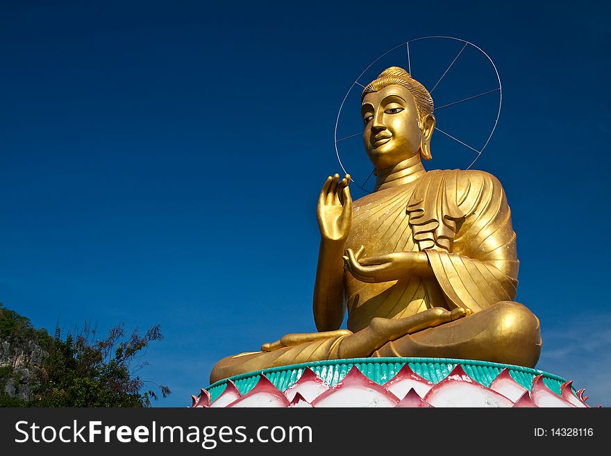 A big golden buddha in blue sky.