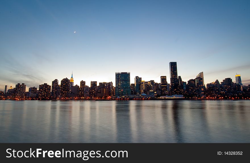 The New York City illuminates at dusk over the East River. The New York City illuminates at dusk over the East River.