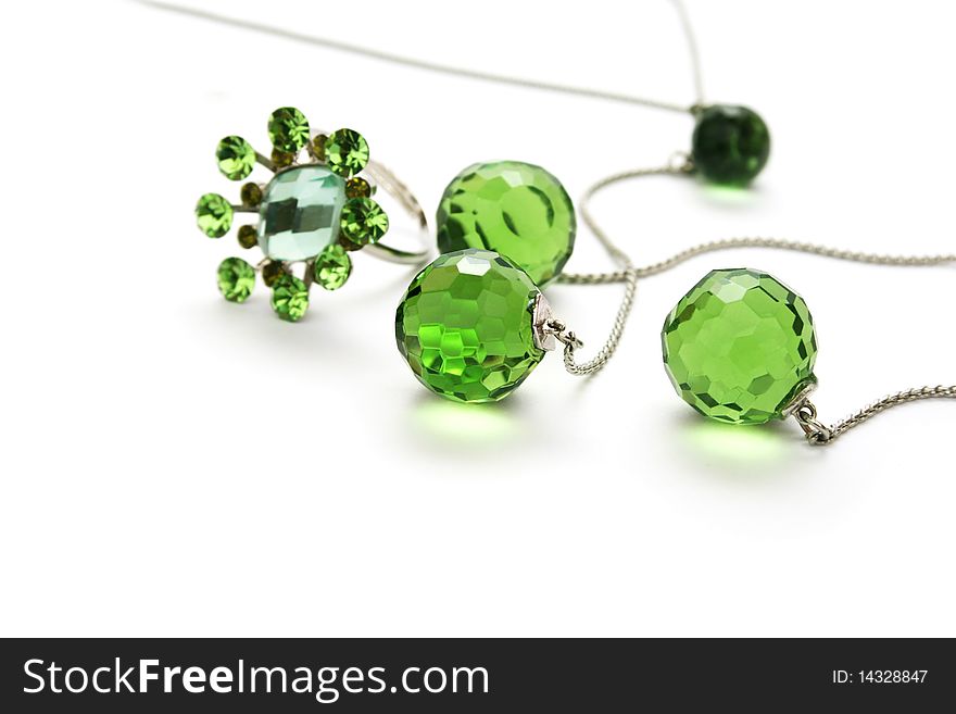 Necklace and ring with green transparent gemstones isolated on white background.