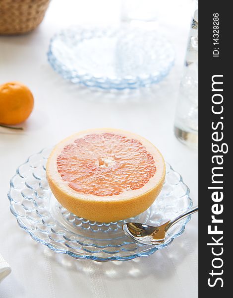 Fresh Pink Grapefruit half on glass plate with spoon. Fresh Pink Grapefruit half on glass plate with spoon