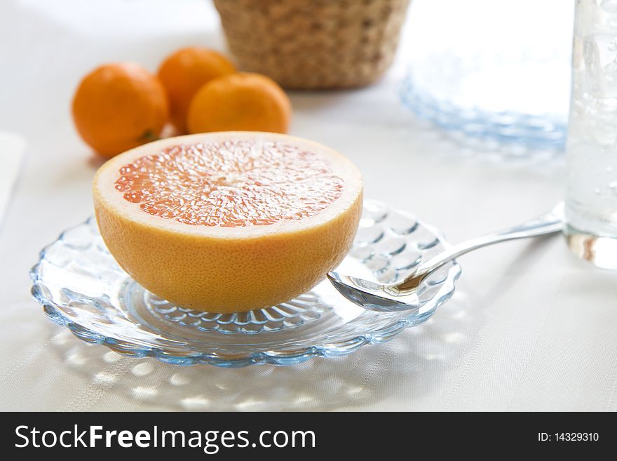 Fresh Pink Grapefruit half on glass plate with spoon. Fresh Pink Grapefruit half on glass plate with spoon