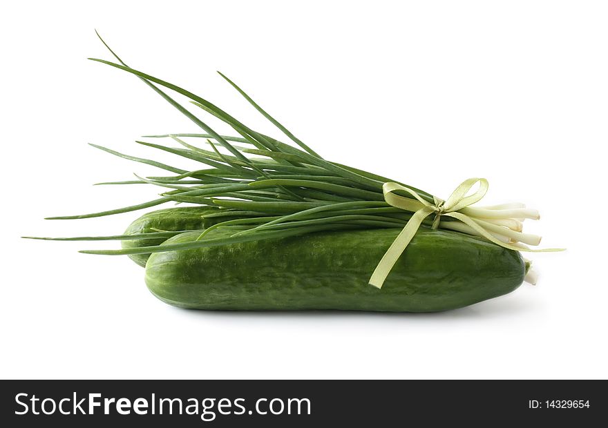 A bunch of green onions and cucumbers on a white background