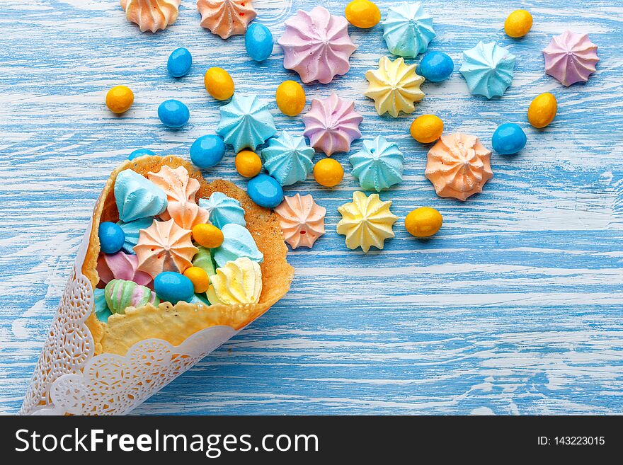 Blue wooden table full of candies, lollipops, cookies and sweet unhealthy food