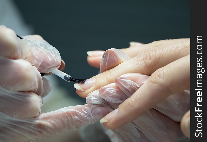 Applying nail Polish in the nail salon. Close up.