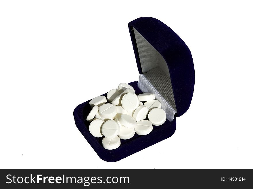 Heap of white tablets in a dark blue box on a white background. Heap of white tablets in a dark blue box on a white background