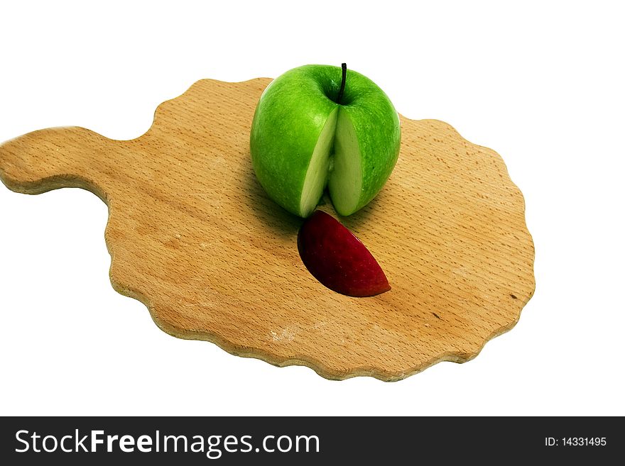 The green apple, cut on a chopping board, with a red part. The green apple, cut on a chopping board, with a red part