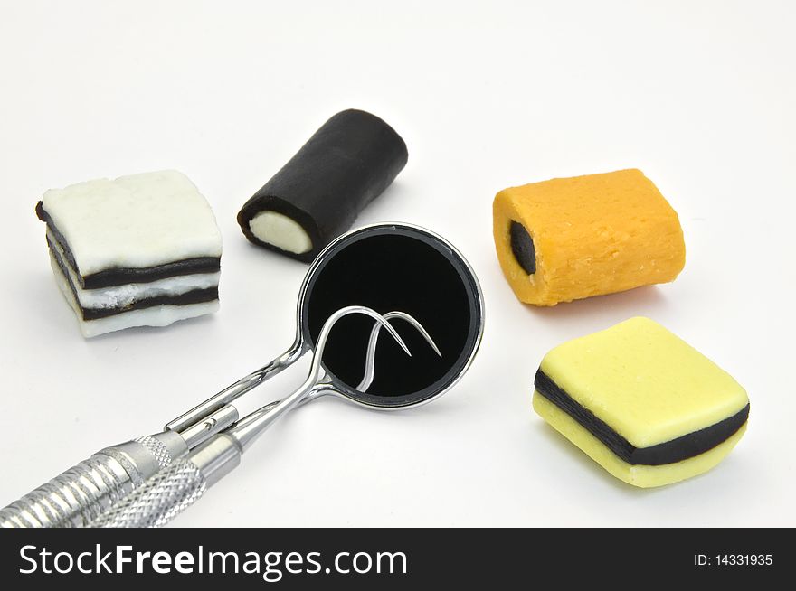 Colored  candies and dental tools on a white background