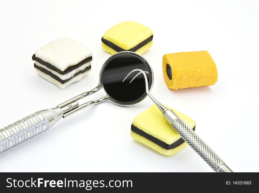 Colored candies and dental tools on a white background