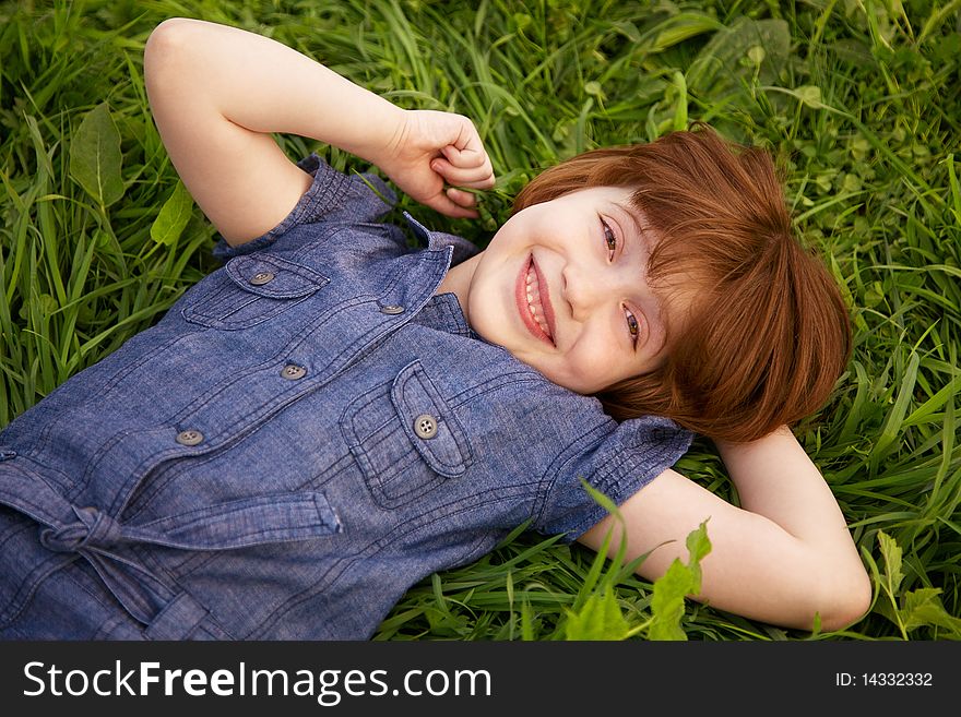 Happy little girl lying on grass