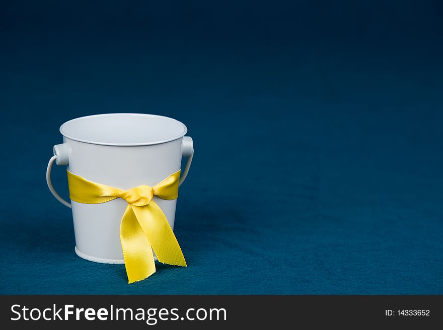 Small white bucket on a blue background. Small white bucket on a blue background