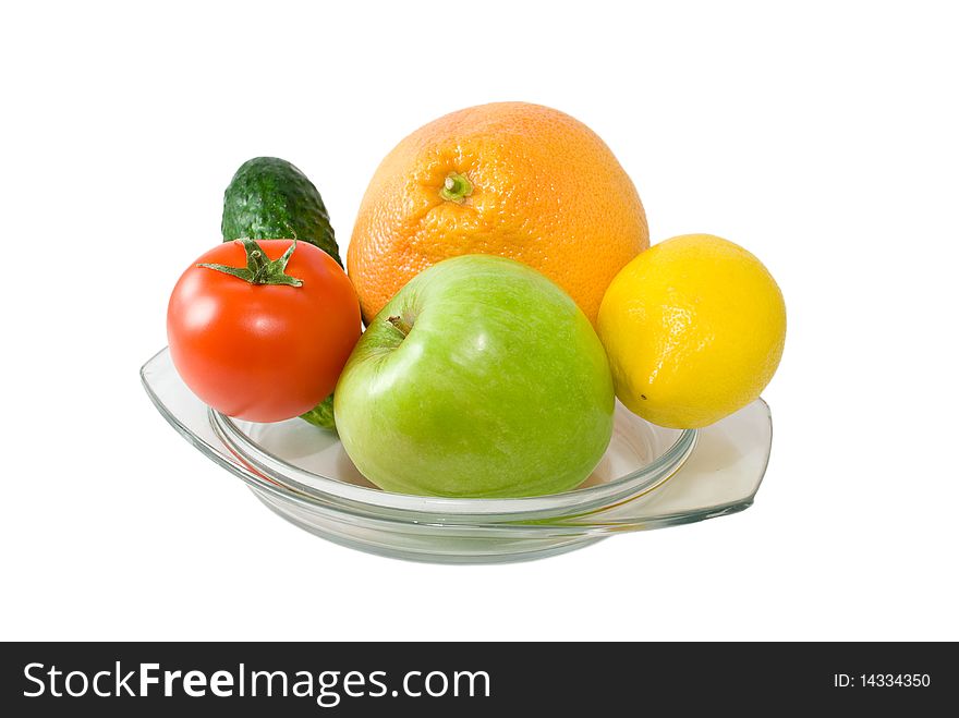 Fruits and vegetables on plate isolated on white background