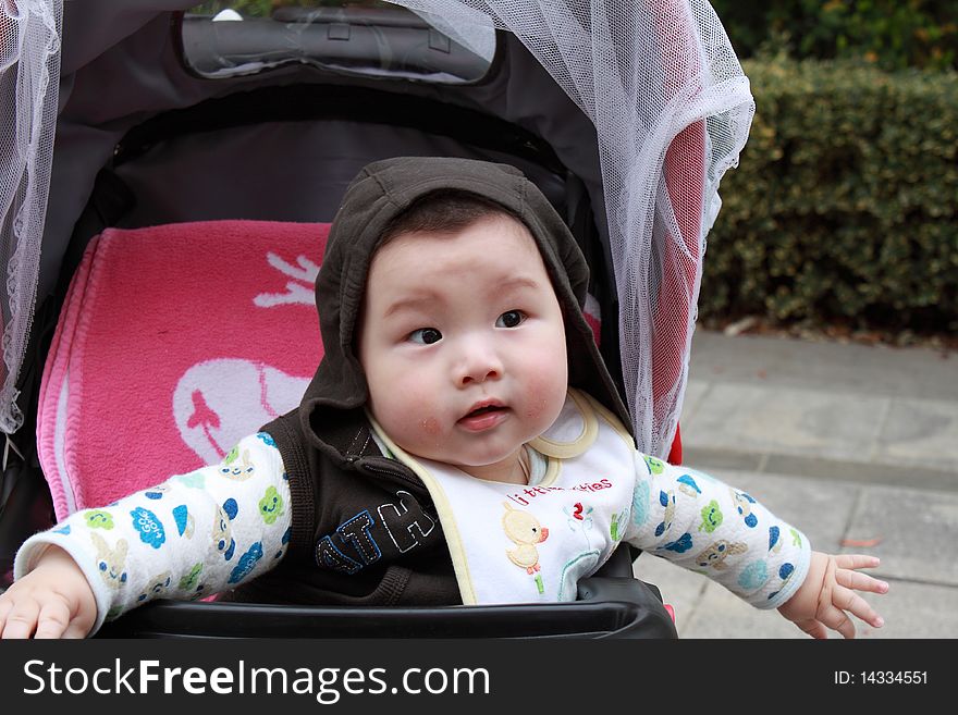 Lovely Chinese baby is sitting in the stroller