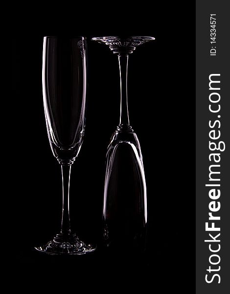 The empty wineglasses on black background. Glass dishware.