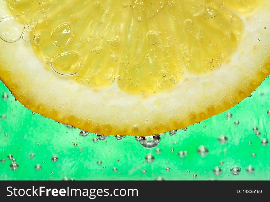 Close up on a lemon slice in a cocktail.