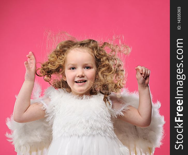 Beautiful little angel girl isolated on pink background