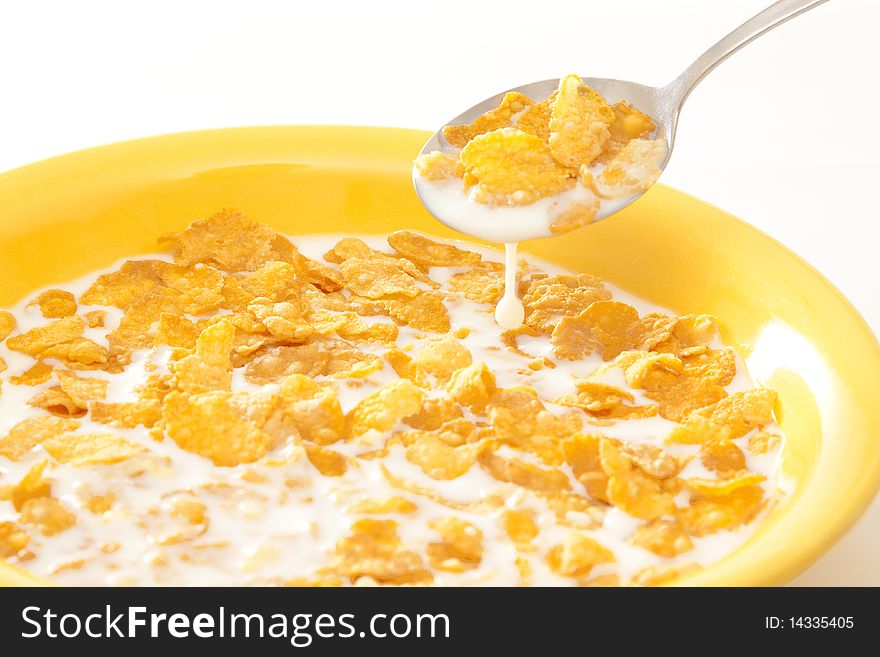 Healthy breakfast - delicious corn flakes with milk in a yellow pot. Healthy breakfast - delicious corn flakes with milk in a yellow pot