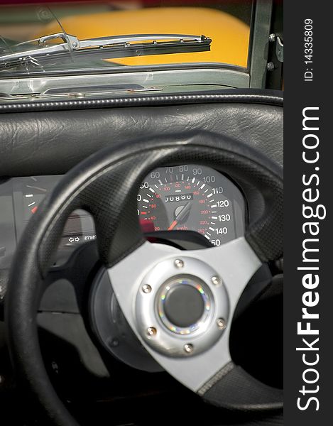 Speedometer and steering wheel detail on a vintage car