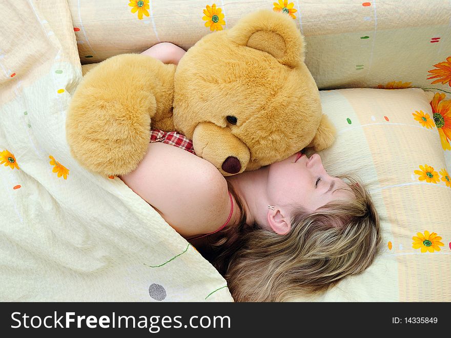 Young girl asleep in her bed with a teddy bear. Young girl asleep in her bed with a teddy bear