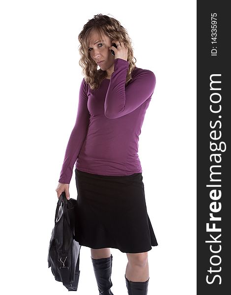 A woman with a briefcase is on her cell phone looking upset. A woman with a briefcase is on her cell phone looking upset.