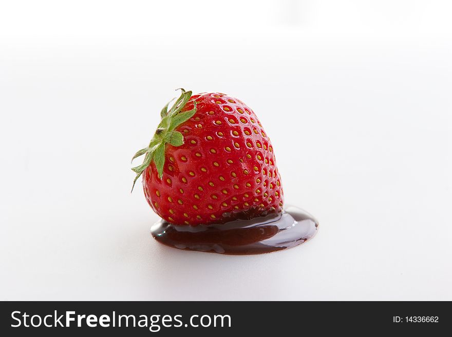 Single ripe fresh strawberry with chocolate cream isolated on white. Clipping path included