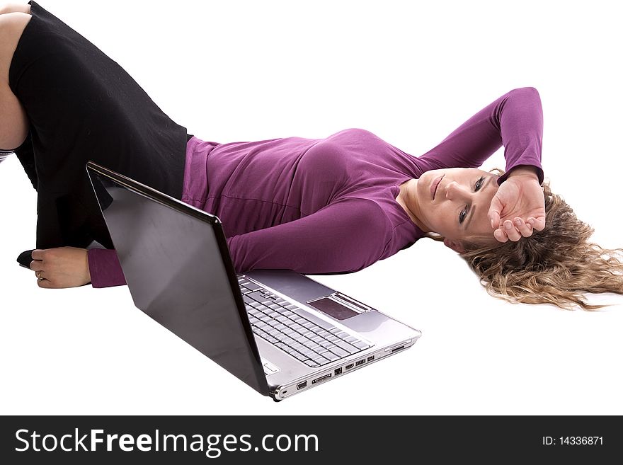 A woman is very tired and laying on the ground by her laptop. A woman is very tired and laying on the ground by her laptop.