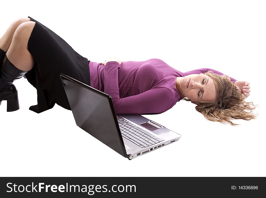 A woman is asleep laying by her lap top computer. A woman is asleep laying by her lap top computer