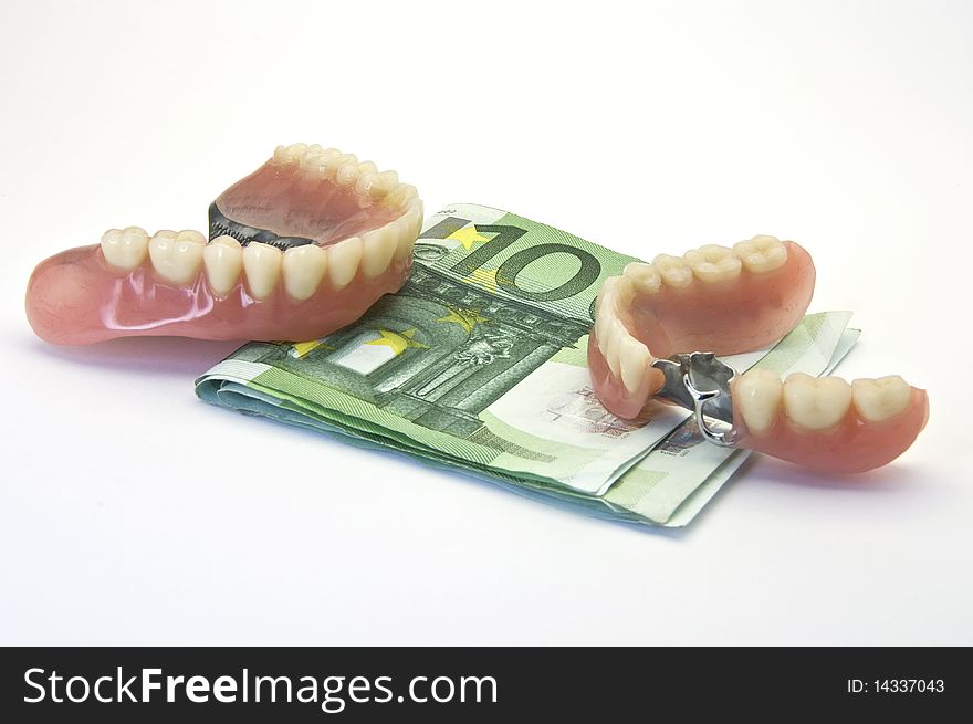 Dentures and money on white background