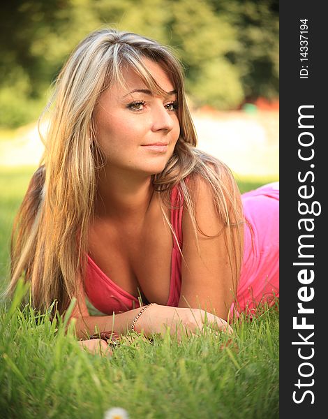 Beautiful young woman relaxing on a grass. Beautiful young woman relaxing on a grass