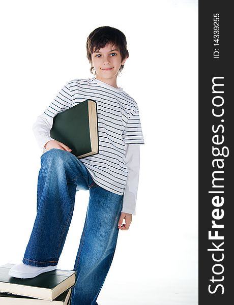 Cute little boy near the stack of big books on white background