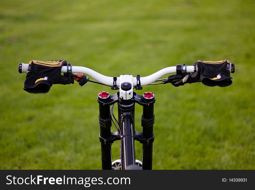 Handlebar of a downhill bike on a field. Handlebar of a downhill bike on a field