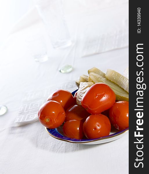 Salted tomatoes and pickled cucumbers on plate
