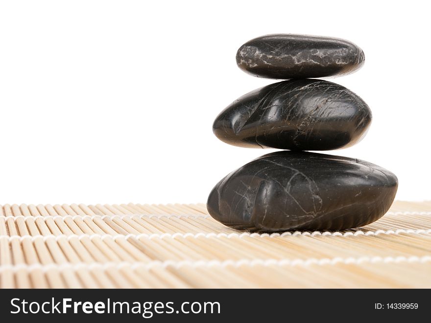 Some dark stones lie on mat isolated in white