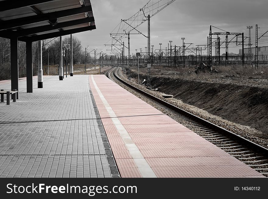 Railroad track and platform with industrial background