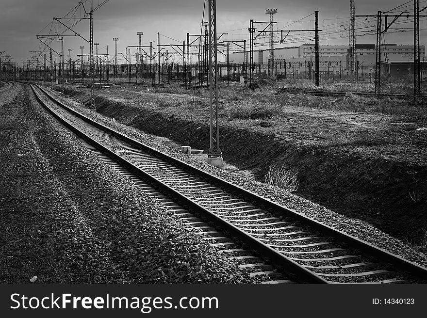 Single railroad track with industrial background
