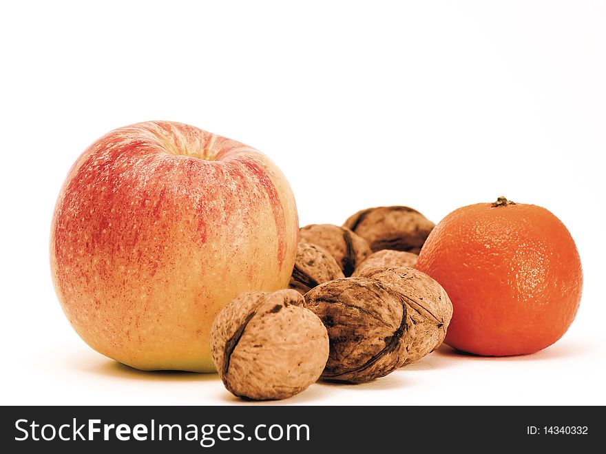 Apple, orange and walnuts on white background.