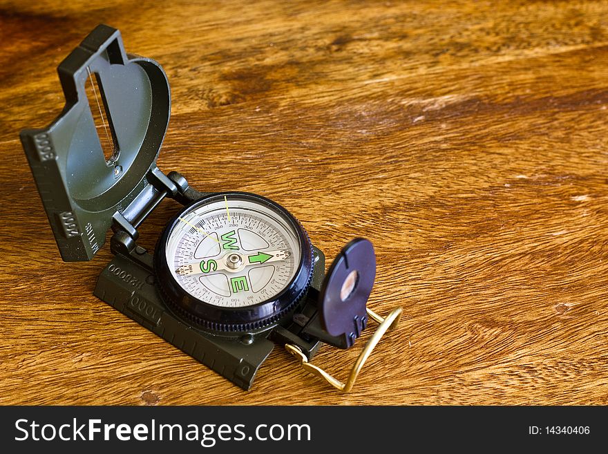 Military compass on wooden table