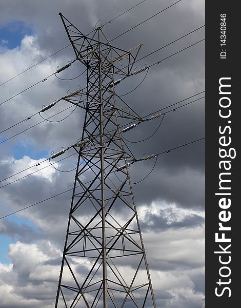 A tall electricity pylon set against a moody sky