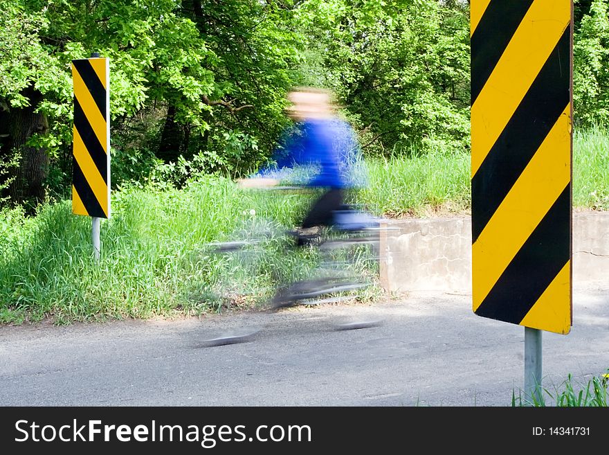 Motion blur of man on bike on rural road. Motion blur of man on bike on rural road