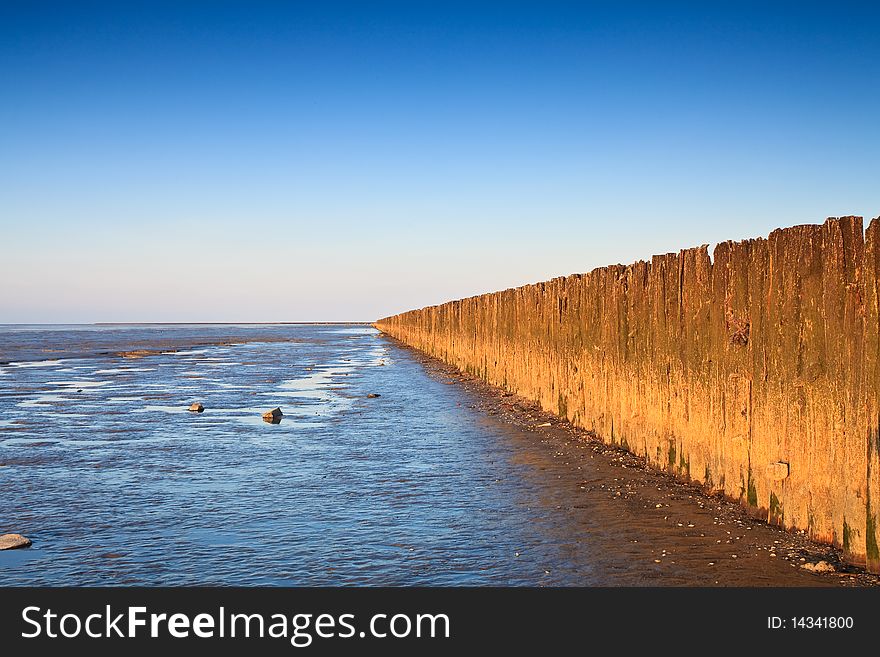 Poles in the ocean at sunset