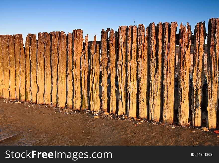 Poles in the ocean at sunset