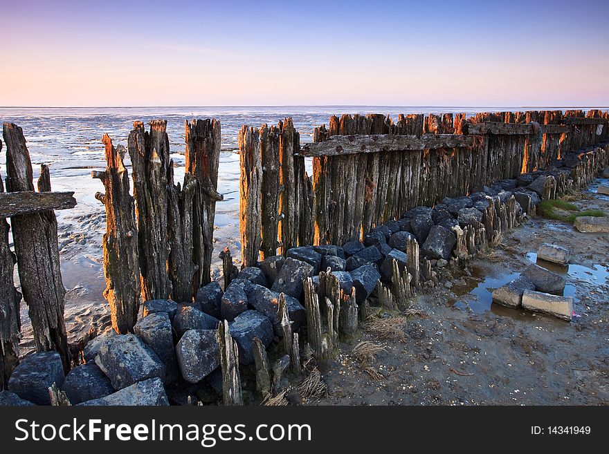 Poles In The Ocean At Sunset