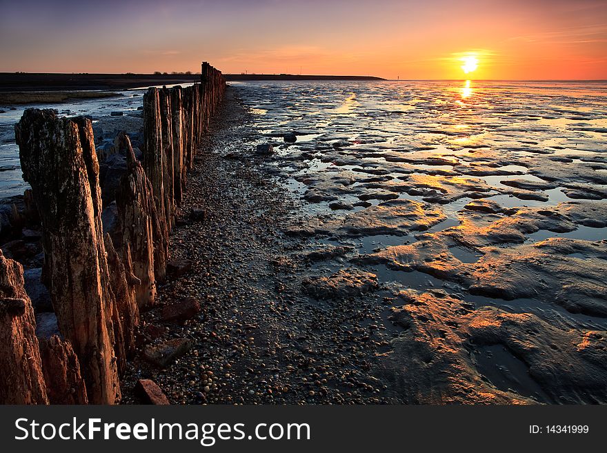 Poles in the ocean at sunset