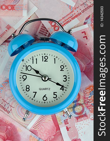 A blue timekeeper with a lot of money bills, means time is money or time value and cost.
