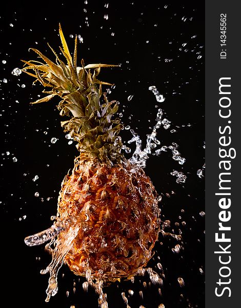 Pineapple on a black background with water drops