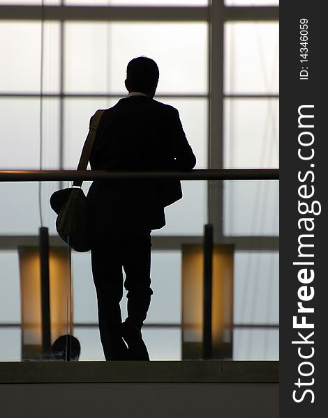 Silhouette of businessman leaning against rail. Silhouette of businessman leaning against rail